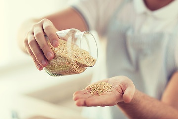 Image showing close up of male emptying jar with quinoa