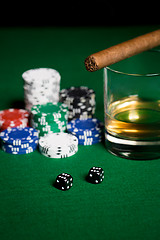 Image showing close up of chips, dice, whisky and cigar on table