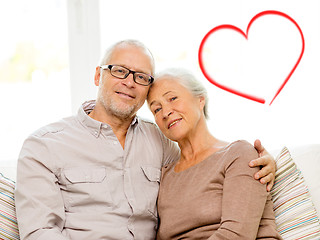 Image showing happy senior couple hugging on sofa at home