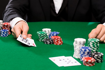 Image showing poker player with cards and chips at casino