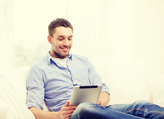 Image showing smiling man working with tablet pc at home