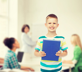 Image showing smiling little student boy with blue book