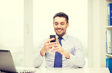 Image showing businessman with laptop and smartphone at office