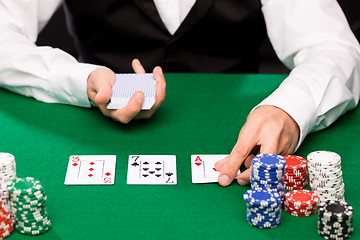 Image showing holdem dealer with playing cards and casino chips
