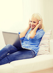 Image showing woman with laptop computer and headphones at home