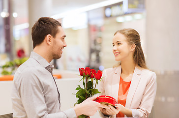 Image showing happy couple with present and flowers in mall