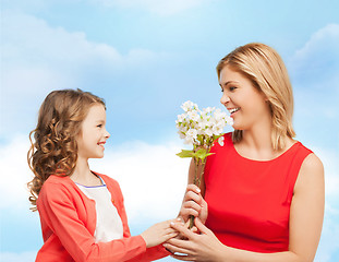 Image showing happy little daughter giving flowers to her mother