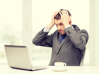 Image showing busy businessman with laptop and coffee