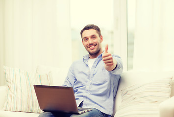 Image showing smiling man working with laptop at home