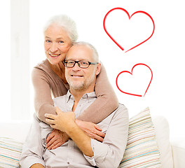 Image showing happy senior couple hugging on sofa at home