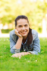 Image showing smiling young girl lying on grass