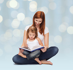 Image showing happy mother with adorable little girl and book