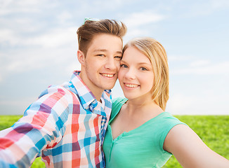 Image showing smiling couple with smartphone in suburbs