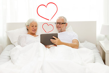 Image showing happy senior couple with tablet pc at home