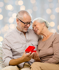 Image showing happy senior couple with red gift box