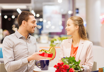 Image showing happy couple with present and flowers in mall