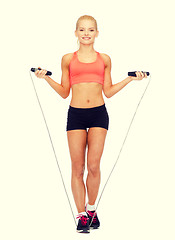 Image showing smiling sporty woman with with skipping rope