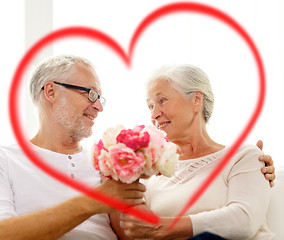 Image showing happy senior couple with bunch of flowers at home