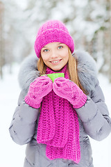 Image showing smiling young woman with cup in winter forest