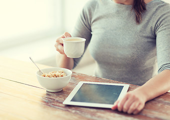 Image showing woman drinking coffee and using tablet pc