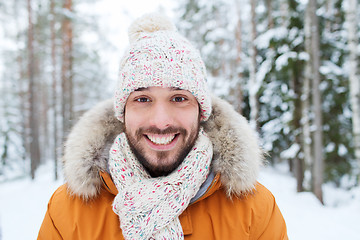 Image showing smiling young man in snowy winter forest