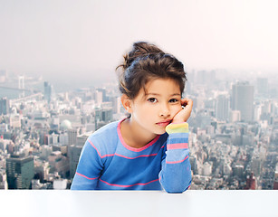 Image showing sad little girl over city background
