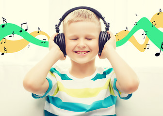 Image showing smiling little boy with headphones at home