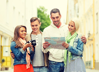 Image showing group of smiling friends with map and photocamera