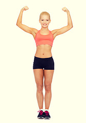 Image showing smiling sporty woman flexing her biceps