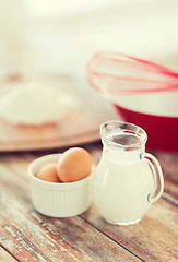 Image showing jugful of milk, eggs in a bowl and flour