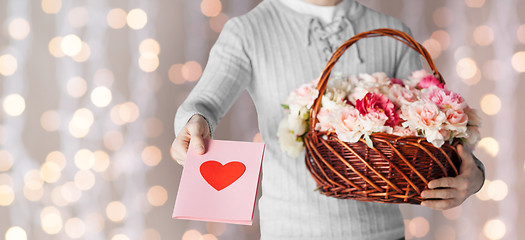 Image showing man holding basket full of flowers and postcard