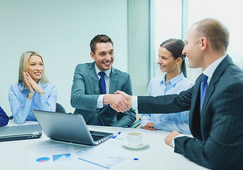 Image showing two businessman shaking hands in office