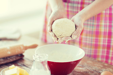 Image showing close up of female hands kneading dough at home