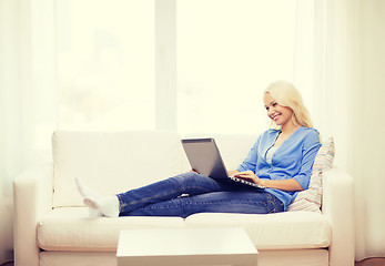 Image showing smiling woman with laptop computer at home