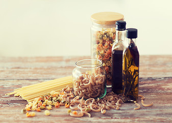 Image showing close up of two olive oil bottles and pasta in jar