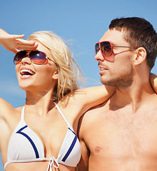 Image showing happy couple in sunglasses on the beach