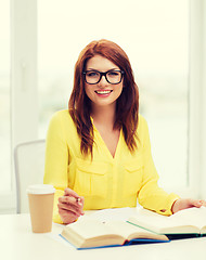 Image showing smiling student girl reading books in library