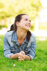 Image showing smiling young girl lying on grass