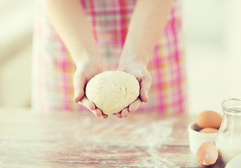 Image showing close up of female hands holding bread dough