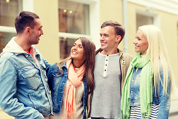 Image showing group of smiling friends walking in the city