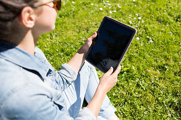 Image showing close up of girl with tablet pc sitting on grass