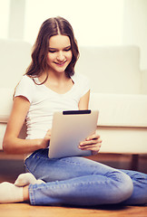 Image showing smiling teenage girl with tablet pc at home