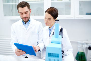 Image showing scientists with tablet pc and microscope in lab