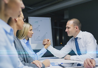 Image showing businesswoman and businessman arm wrestling