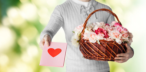 Image showing man holding basket full of flowers and postcard