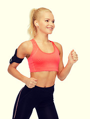 Image showing sporty woman running with smartphone and earphones