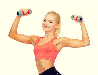 Image showing smiling beautiful sporty woman with dumbbells