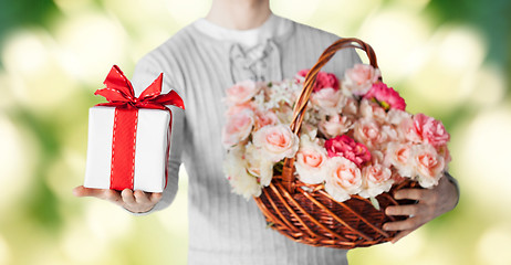 Image showing man holding basket full of flowers and gift box