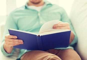 Image showing close up of man reading book at home