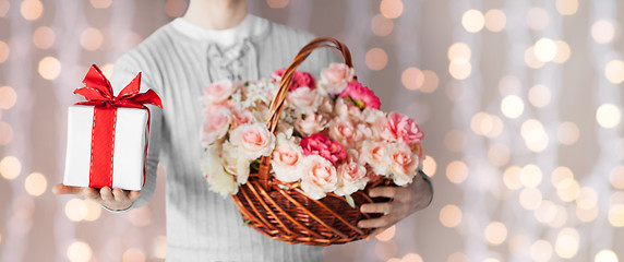 Image showing man holding basket full of flowers and gift box